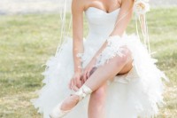 a beautiful ballerina wedding dress with a strapless corset top and a feather skirt with a train