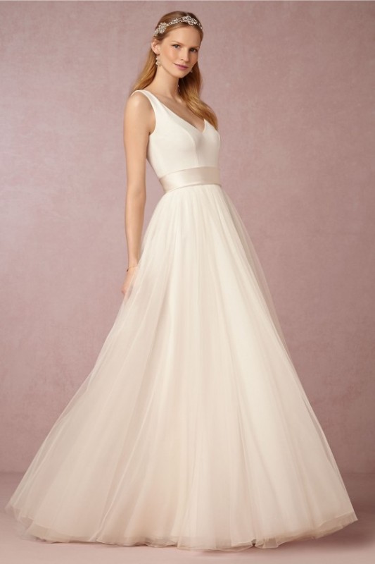 a modern ballerina-inspired look with a sleek sleeveless bodice with a deep cut and a pleated maxi skirt with a train