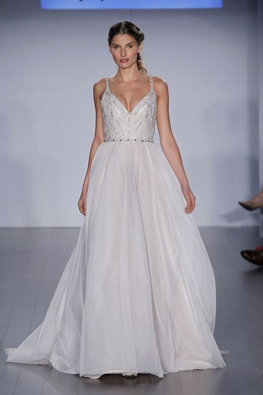 an A-line wedding dress with a heavily embellished bodice, thick straps and a layered skirt plus a train