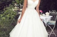 an a-line midi wedding dress with no sleeves, an illusion bodice and a full skirt for a look with a retro touch