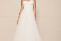 a romantic A-line wedding dress with an applique bodice with spaghetti straps, a full tulle skirt looks very refined and very chic