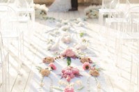 a botanical wedding ceremony space with a pampas grass altar, ombre blooms lining up the aisle