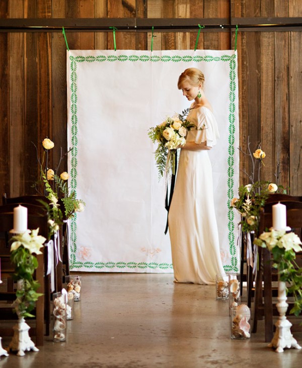 a cool embroidery wedding backdrop with botanical motifs, some whimsical arrangements decorating the aisle