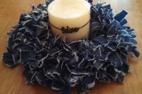 a candle wrapped with a lush denim wreath and a letter pendant is a fun and quirky cowboy decoration