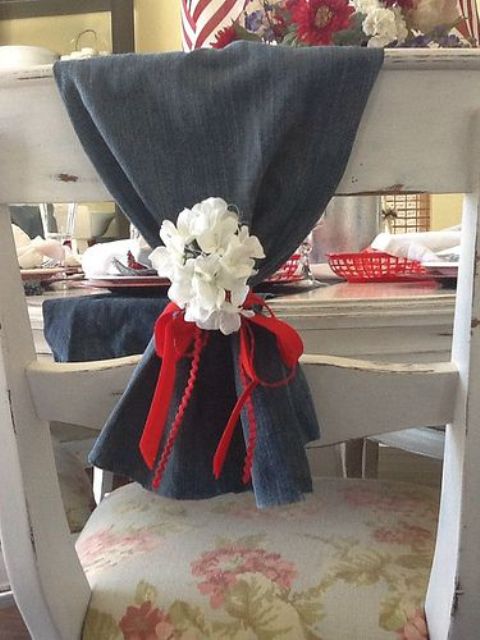 a denim table runner with white blooms and a red ribbon bow for accenting a table