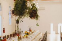 hanging greenery arrangements paired with bulbs will make the reception space fresh, natural and lit up and cozy