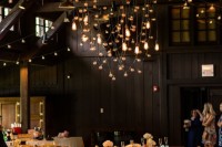a barn wedding reception with neutral blooms, candles and bulbs hanging over the table is a lovely idea to rock