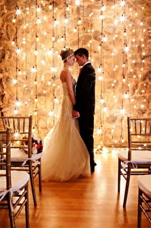 a gorgeous wedding backdrop that is easy to DIY - a wall with lots of bulbs hanging down is a very romantic idea