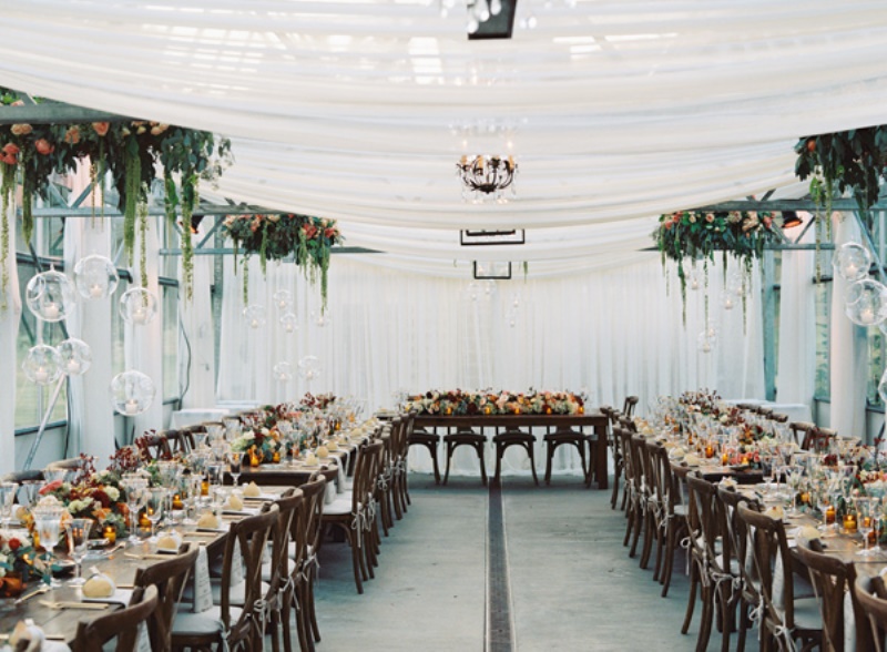greenery and bright blooms over the tables and bold blooms on the tables make the space lovely and welcoming