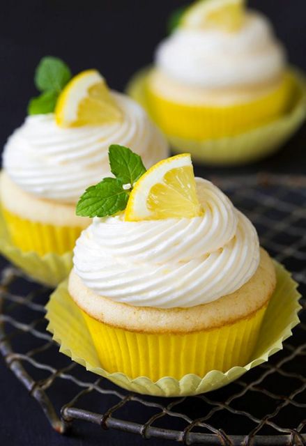lemon cupcakes with frosting and lemon slices and mint on top are adorable for a summer or spring wedding