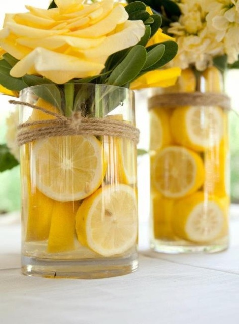 a bold wedding centerpiece of tall clear vases filled with lemon slices and yellow roses are amazing as a bold touch to the tablescape