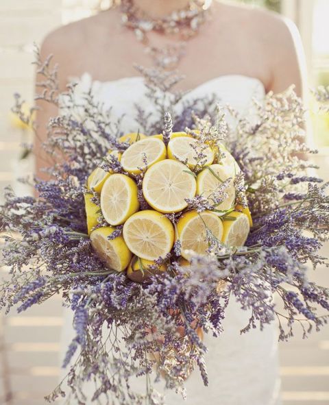 a unique wedding arrangement of cut lemons and lots of lavender and grasses is a creative wedding centerpiece to rock