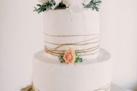 a white textural wedding cake wrapped with twine, blush and white blooms and greenery is a beautiful idea for a rustic wedding