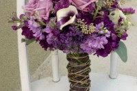 a bright wedding bouquet of purple and lilac blooms and greenery with a twine wrap to give a rustic feel to the bouquet