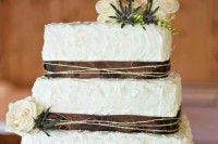 a rustic textural buttercream wedding cake wrapped with ribbon and twine and with white blooms is a chic idea