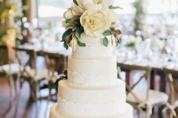 a white lace wedding cake with magnolia leaves and blooms is a cool idea to make a statement at the wedding