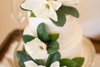 a white wedding cake decorated with magnolia flowers is a very elegant and chic idea