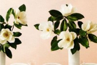 tall wedding centerpieces with white vases and lush magnolia arrangements are a chic and bold idea