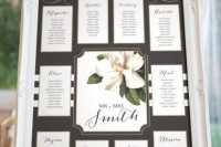 a wedding seating chart is done with a chalkboard and a printed magnolia for a slight southern touch in decor