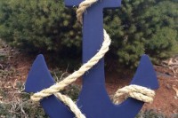 a navy anchor wrapped with rope is a stylish and cool decoration for a nautical wedding, or a seaside one, and you can DIY it