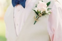 a delicate groom’s look with a blush shirt, a neutral waistcoat, a navy bow tie and a blush bloom boutonniere accented with an anchor