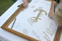 a wedding guest book featuring a chic vintage frame and a large anchor print is a stylish idea for a refined wedding