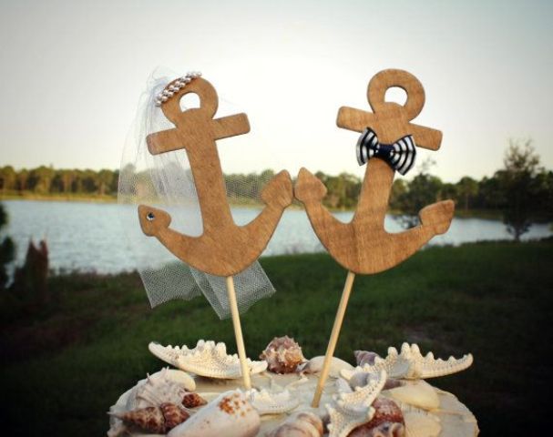 a neutral wedding cake topped with seashells and plywood anchors is a stylish solution for a seaside or nautical wedding