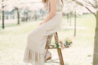a lovely white and coral floral crown paired with an off-white wedding dress create a look of a charming nymph from a magic garden