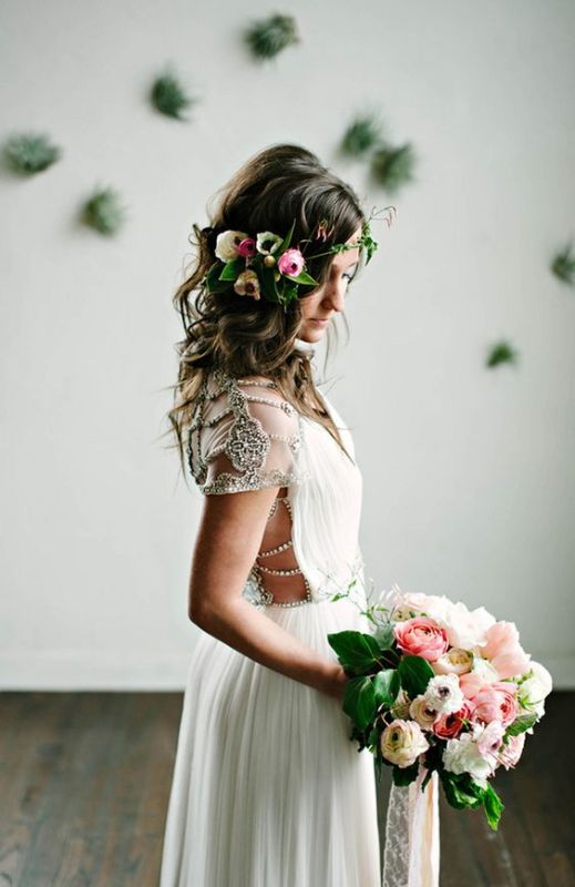a beautiful spring boho bridal look with a flowy wedding dress with embellishments and a floral accent in the hair plus a matching wedding bouquet