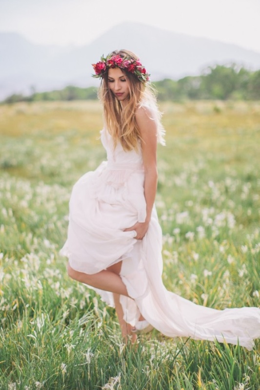 a boho bridal look with a flowy wedding dress with a train and bold flower crown is a romantic and cool solution