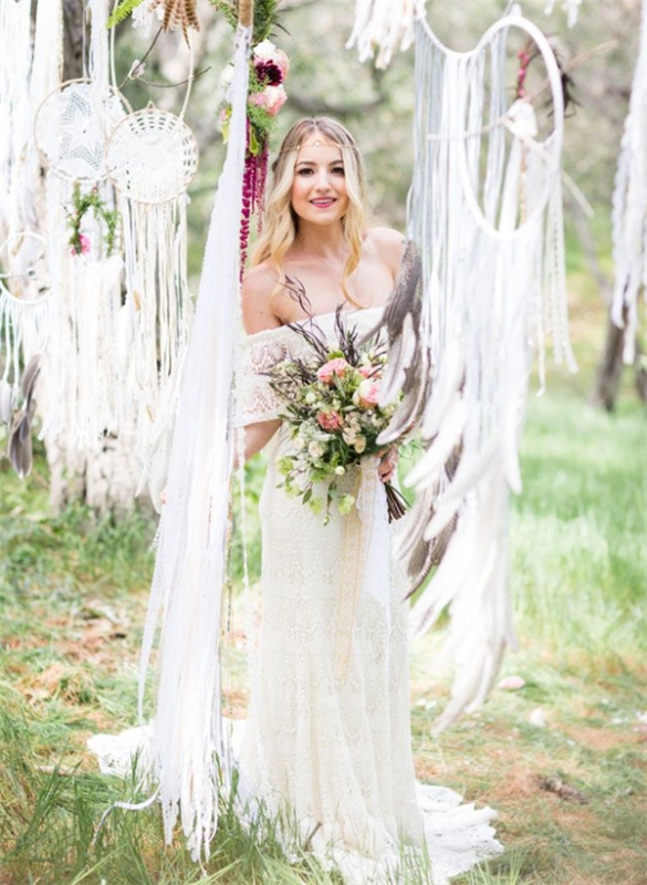 a chic boho spring bridal look with an off the shoulder lace wedding dress, an embellished headpiece and a pink wedding bouquet