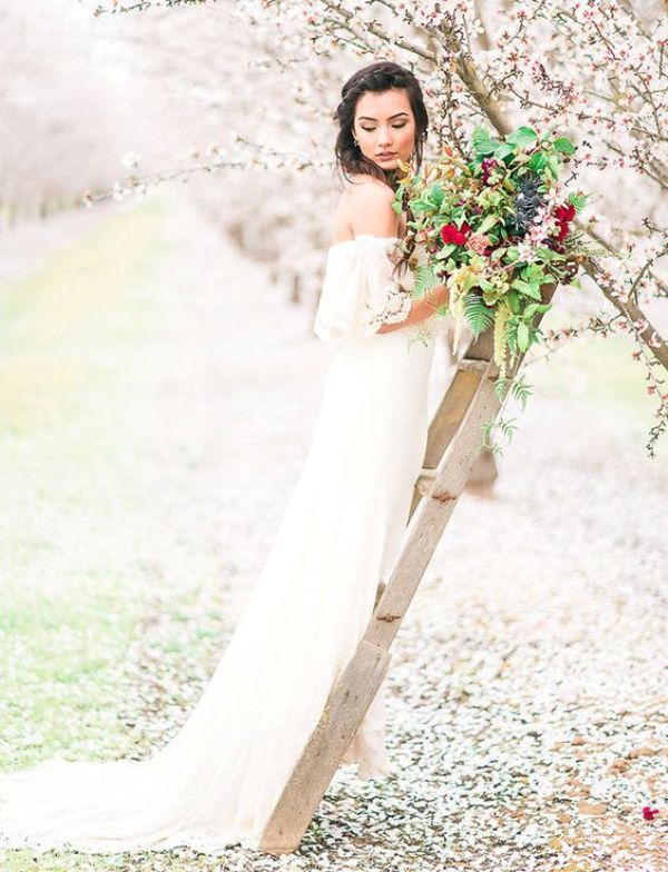 a spring boho bridal look with a lace off the shoulder wedding dress and a bright wedding bouquet is amazing for spring