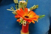 an orange gerbera and waxflower boutonniere is a lovely and colorful accessory for a groom’s look