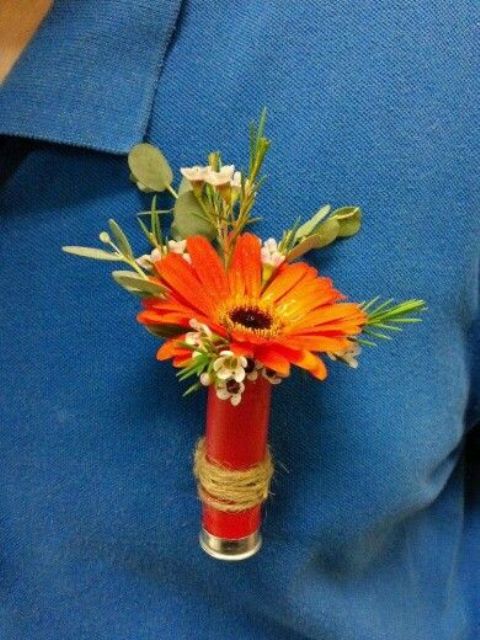 an orange gerbera and waxflower boutonniere is a lovely and colorful accessory for a groom's look