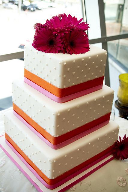 a square polka dot wedding cake with colorful ribbon and bold pink gerberas on top is amazing for a bold spring or summer wedding