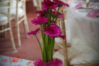 a bold pink gerbera wedding centerpiece in a bowl is a catchy and simple idea for a bright wedding