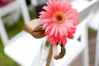 a bright pink gerbera with a bow to accent a wedding aisle chair is a simple and cool way to make your aisle bolder