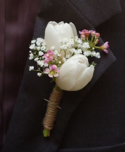 a small and lovely wedding boutonniere of white tulips, baby's breath and rope wrap is a lovely idea for a rustic wedding