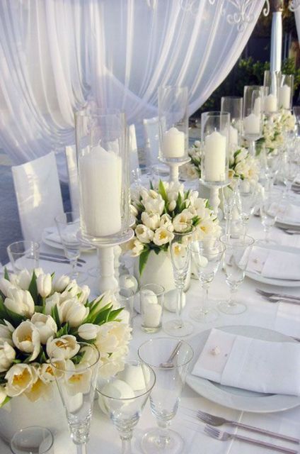 a super elegant all-white wedding tablescape with white tulips, candles and stylish white porcelain is a lovely idea for a modern wedding