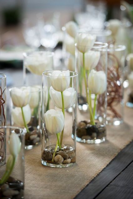 cool cluster wedding centerpiece of tall vases with white tulips and pebbles inside are amazint to make your wedding tablescape chic and cool