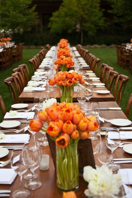 super bright wedding centerpieces of orange tulips are amazing for a bold spring or summer wedding