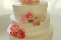 a white buttercream wedding cake decorated with pink tulips is a lovely idea for a spring or summer wedding