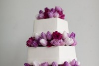 a white square wedding cake with purple, white and lilac tulips is a stylish and cool idea of a wedding dessert for spring or summer