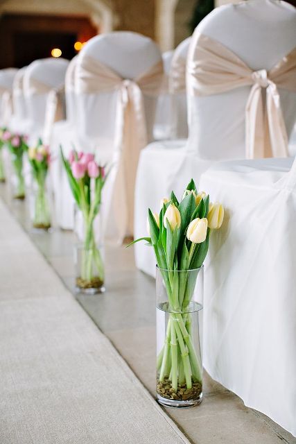 clear vases with tulips lining up the aisle are amazing to style your wedding ceremony space in a simple and cool way