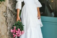 a beautiful and dreamy boho lace A-line wedding dress with long sleeves, a square neckline and a tiered skirt with a train