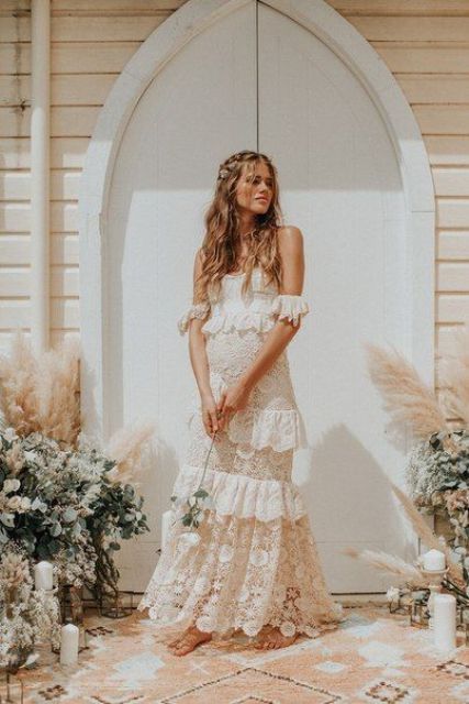 a beautiful boho lace off the shoulder wedding dress with ruffles and ruffles instead of sleeves is amazing for a boho spring bride