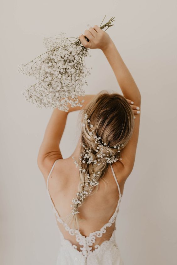 a beautiful boho wedding hairstyle - a long braid accented with white baby's breath is a lovely idea for a boho spring wedding