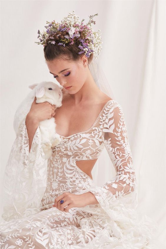 a beautiful spring boho wedding look wiht a delicate lace applique wedding dress with side cutouts and bell sleeves, a lilac and white flower crown