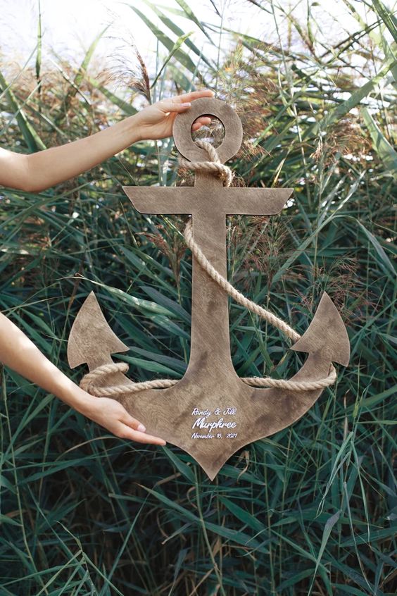 a big anchor wedding guest book of wood, with rope is a stylish idea for a nautical wedding
