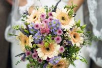 a colorful wedding bouquet of yellow gerberas, pink and lilac blooms and greenery is amazing for a bright wedding